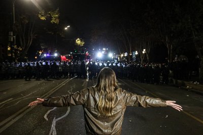 Дівчина стоїть перед поліцією під час акції протесту в Тбілісі Дівчина стоїть перед поліцією під час акції протесту в Тбілісі
