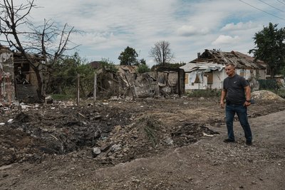 Чоловік біля руїн будинку Чоловік біля руїн будинку