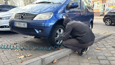 Працівник шиномонтажу замінює колесо на автівці. Миколаїв, листопад 2025 року Працівник шиномонтажу замінює колесо на автівці. Миколаїв, листопад 2025 року