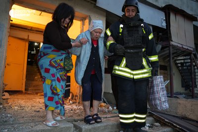 Жінка з рятувальником допомагають вийти літній сусідці з дому на Салтівці у Харкові, в який влучив російський дрон Жінка з рятувальником допомагають вийти літній сусідці з дому на Салтівці у Харкові, в який влучив російський дрон