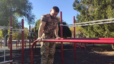 Абсолютний чемпіон України з натурального бодибілдингу Олександр робить вправу на тренажері Абсолютний чемпіон України з натурального бодибілдингу Олександр робить вправу на тренажері