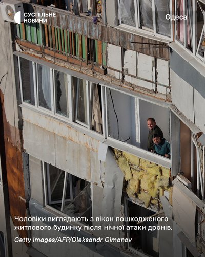 Чоловіки виглядають з розбитих вікон пошкодженого житлового будинку після нічної атаки дронів по Одесі Чоловіки виглядають з розбитих вікон пошкодженого житлового будинку після нічної атаки дронів по Одесі