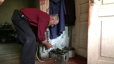 Чоловік підключає електрику від акумулятора Чоловік підключає електрику від акумулятора