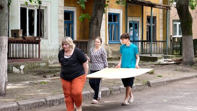 Містяни несуть OSB-дошку наслідки обстрілу Краматорськ Донецька область 2 липня 2025 рік Містяни несуть OSB-дошку наслідки обстрілу Краматорськ Донецька область 2 липня 2025 рік