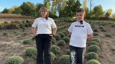 Наталія із сином на ділянці, де ростуть хризантеми Наталія із сином на ділянці, де ростуть хризантеми