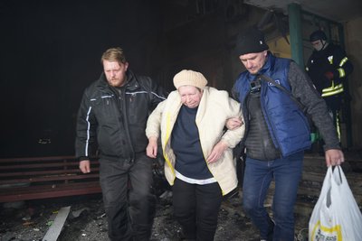 Чоловіки виводять з будинку жительку Харкова після влучання поруч російських безпілотників Чоловіки виводять з будинку жительку Харкова після влучання поруч російських безпілотників