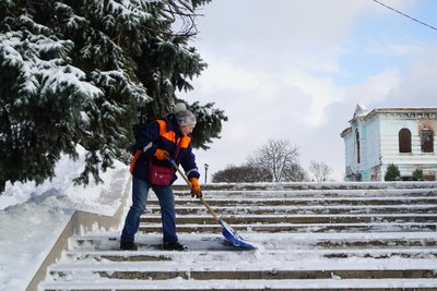 Працівниця комунального підприємства прибирає сніг, Ізюм Працівниця комунального підприємства прибирає сніг, Ізюм