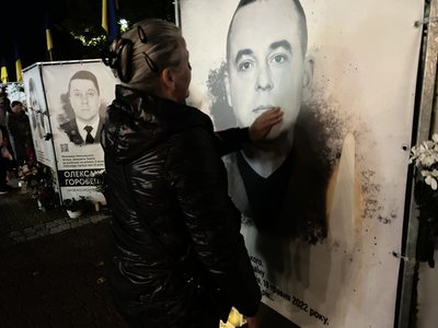 Учасниця акції поряд з портретом загиблого військового Учасниця акції поряд з портретом загиблого військового