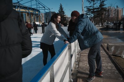 Чоловік та жінка біля бортику ковзанки Чоловік та жінка біля бортику ковзанки