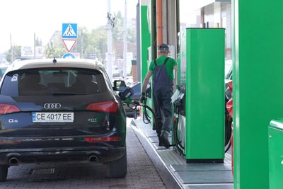 Оператор на одній із заправок міста Чернівці заправляє автомобіль Оператор на одній із заправок міста Чернівці заправляє автомобіль