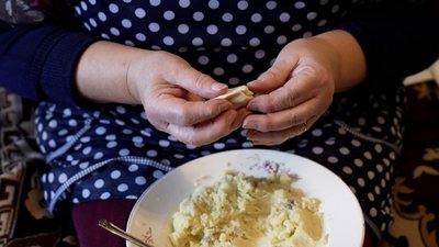 Жінка ліпить вареники для захисників, які проходять лікування Жінка ліпить вареники для захисників, які проходять лікування