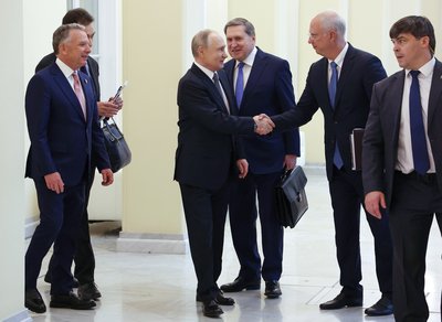 Лідер Росії Володимир Путін тисне руку своєму представнику на переговорах з делегацією США, гендиректору російського Фонду прямих інвестицій Кирилу Дмитрієву Лідер Росії Володимир Путін тисне руку своєму представнику на переговорах з делегацією США, гендиректору російського Фонду прямих інвестицій Кирилу Дмитрієву