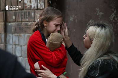 Жінка заспокоює дівчинку у стані стресу після влучання безпілотника в їхній будинок у Соломʼянському районі Києва Жінка заспокоює дівчинку у стані стресу після влучання безпілотника в їхній будинок у Соломʼянському районі Києва