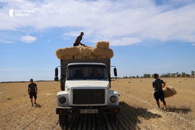 Робітники фермерського господарства приїхали вантажівкою збирати сіно в тюках. Херсонщина, липень 2025 року