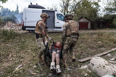 Поліцейські евакуйовують жінку, яка не може сама ходити