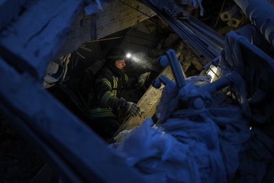 Рятувальник шукає під завалами будинку людей, які могли потрапити під обстріл у Херсоні
