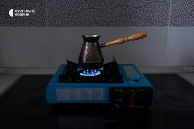 На переносній газовій конфорці родина може нагріти їжу та воду для гарячих напоїв у години відключення світла На переносній газовій конфорці родина може нагріти їжу та воду для гарячих напоїв у години відключення світла
