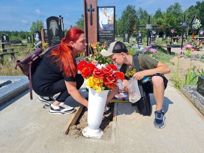 Лілія Кузьменко із сином на могилі свого загиблого чоловіка Лілія Кузьменко із сином на могилі свого загиблого чоловіка
