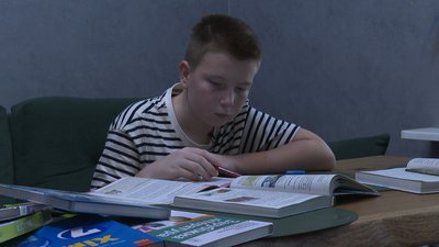Семикласник Максим Жаднов продивляється свої шкільні підручники Семикласник Максим Жаднов продивляється свої шкільні підручники