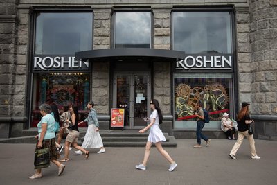 Люди проходять повз кондитерський магазин Roshen у центрі Києва, 29 липня 2022 року. Корпорація Roshen є одним з найбільших виробників кондитерських виробів в Україні та Східній Європі. Її засновником є п'ятий президент України Петро Порошенко Люди проходять повз кондитерський магазин Roshen у центрі Києва, 29 липня 2022 року. Корпорація Roshen є одним з найбільших виробників кондитерських виробів в Україні та Східній Європі. Її засновником є п'ятий президент України Петро Порошенко