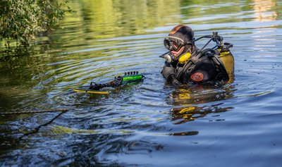 Водолази працюють у воді на території, де стався вибух Водолази працюють у воді на території, де стався вибух