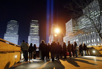 Люди стоять на оглядовому майданчику Ground Zero біля інсталяції Tribute in Light через півроку від дня терористичної атаки на Всесвітній торговий центр в Нью-Йорку, 11 березня 2002 року Люди стоять на оглядовому майданчику Ground Zero біля інсталяції Tribute in Light через півроку від дня терористичної атаки на Всесвітній торговий центр в Нью-Йорку, 11 березня 2002 року