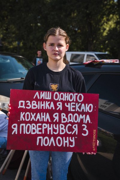Вікторія із плакатом, у якому йдеться, що вона чекає чоловіка Вікторія із плакатом, у якому йдеться, що вона чекає чоловіка