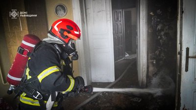 Рятувальник гасить пожежу Рятувальник гасить пожежу