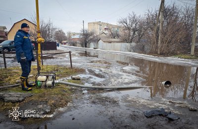 рятувальник відкачує воду через підтоплення рятувальник відкачує воду через підтоплення