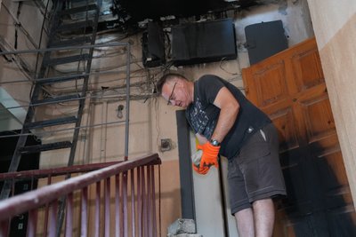 Дмитро Доленко у під'їзді, дах якого був пошкоджений через російське влучання Дмитро Доленко у під'їзді, дах якого був пошкоджений через російське влучання