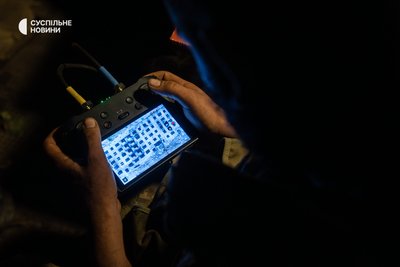 військовий пілотує дрон над зруйнованими багатоповерхівками Часового Яру, Донеччина, 9 липня 2024 року