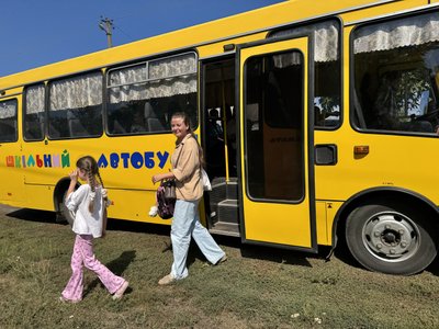 Мати та донька біля шкільного автобуса Мати та донька біля шкільного автобуса