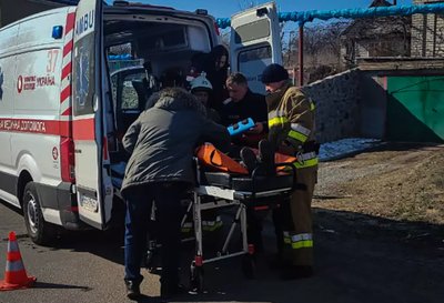 Пораненого внаслідок аварії доставляють до карети "швидкої" Пораненого внаслідок аварії доставляють до карети "швидкої"