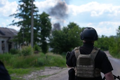 Поліцейський дивиться на дим від влучання Поліцейський дивиться на дим від влучання