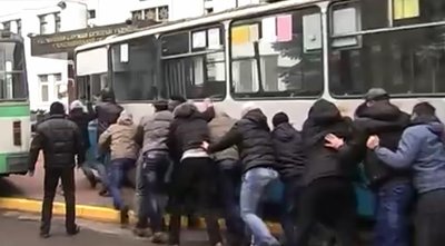 Учасники Революції гідності під час мітингу під стінами Хмельницького обласного Управління СБУ заганяти тролейбуси у ворота будівлі Учасники Революції гідності під час мітингу під стінами Хмельницького обласного Управління СБУ заганяти тролейбуси у ворота будівлі