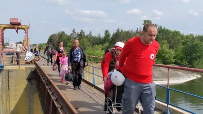 Люди евакуюються через Печенізьку дамбу влітку 2022 року Люди евакуюються через Печенізьку дамбу влітку 2022 року