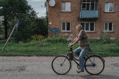 Чоловік їде вулицею на велосипеді Чоловік їде вулицею на велосипеді