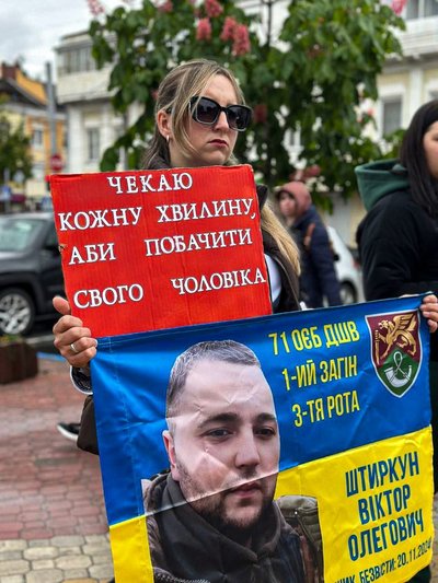 Марина тримає прапор на якому фото її безвісти зниклого чоловіка Марина тримає прапор на якому фото її безвісти зниклого чоловіка
