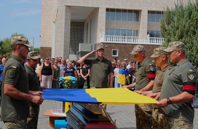 Військові тримають прапор України над труною Військові тримають прапор України над труною