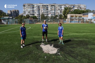 Гравчині дівочої футбольної команди дитячо-юнацької спортивної школи "Кристал" із Херсона тренуються на футбольному полі у спальному районі міста, куди раніше влучив російський снаряд, 6 серпня 2025 року Гравчині дівочої футбольної команди дитячо-юнацької спортивної школи "Кристал" із Херсона тренуються на футбольному полі у спальному районі міста, куди раніше влучив російський снаряд, 6 серпня 2025 року