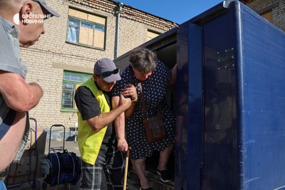 На точці, куди волонтери привозять евакуйованих жителів Острова для реєстрації і, за необхідності, подальшого розподілення, волонтери допомагають літнім людям вийти з бронемобіля. Херсон, 4 серпня 2025 року