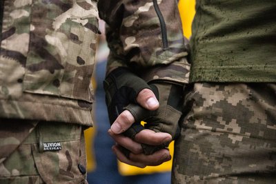 Пара українських військових тримаються за руки під час Маршу рівності у Києві, 16 червня 2024 року