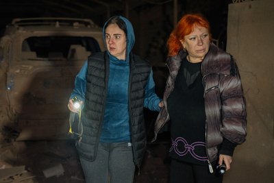 Місцеві жительки спостерігають за пошуковою операцією в Основʼянському районі Харкова, куди влучила російська КАБ в ніч на 29 жовтня 2024 року