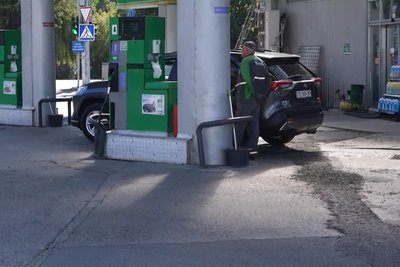 Оператор на одній із заправок міста Чернівці заправляє автомобіль Оператор на одній із заправок міста Чернівці заправляє автомобіль