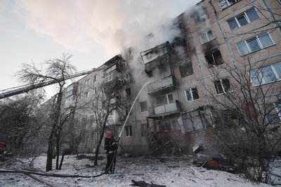 Рятувальник гасить пожежу в будинку, куди влучив російський БпЛА в Салтівському районі Харкова, 3 лютого 2026 року