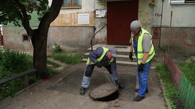 Працівники "Чернігівводаканалу" відкривають люк біля багатоквартирного будинку у Чернігові, де утворюється провалля Працівники "Чернігівводаканалу" відкривають люк біля багатоквартирного будинку у Чернігові, де утворюється провалля