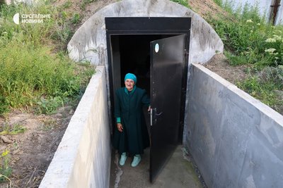 Жінка біля дверей підземного бетонного укриття у Херсоні
