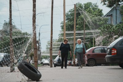 Жінки йдуть в Ізюмі під антидроновими сітками Жінки йдуть в Ізюмі під антидроновими сітками