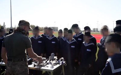 A soldier shows explosives to naval school students A soldier shows explosives to naval school students