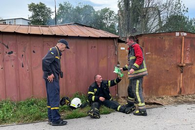 рятувальники відпочивають під час розбору завалів у багатоповерхівці в Полтавському районі, 17 червня 2024 року